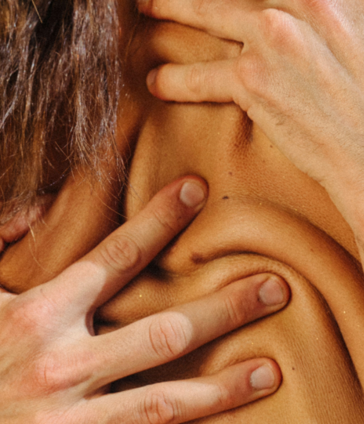 hands covering women's back using massage oil