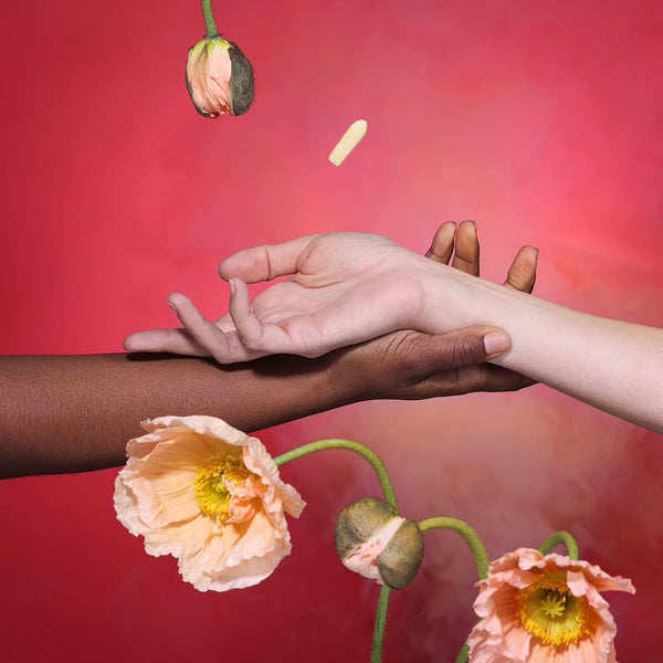 Foria Intimacy Melts with CBD Two hands reaching towards each other with flowers on a gradient red and pink background 