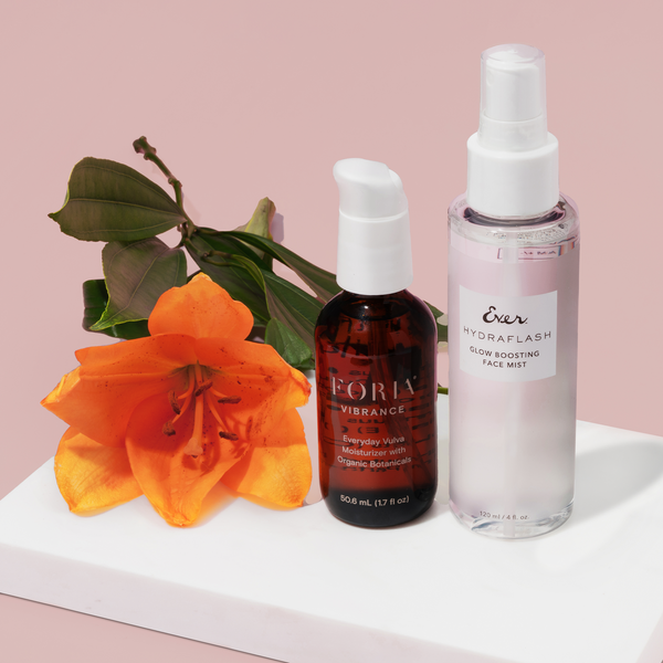 Foria Stay Dewy Duo product set lifestyle on white edge and light pink background