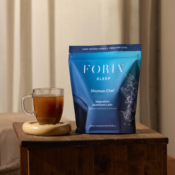 Foria Shuteye Chai adaptogens with ashwagandha benefits, cup of chai on table next to package 