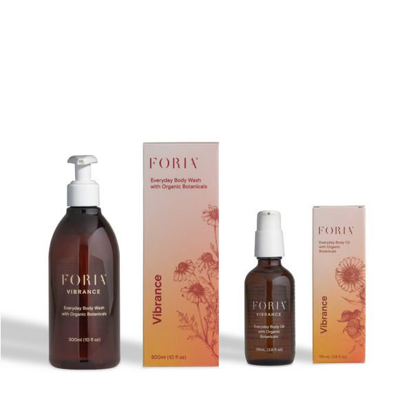 FORIV Vibrance Everyday Body Wash and Everyday Body Oil set, featuring amber glass bottles with white pumps and matching pink-to-orange gradient boxes with botanical illustrations, on a white background.