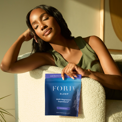 Foria Mellö Magnesium pouch how to relax, women on couch holding magnesium glycinate and magnesium citrate