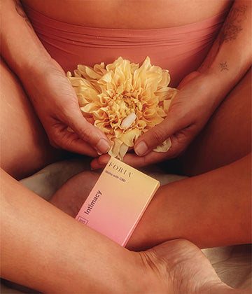 Person holding flower with intimacy melts, made for more pleasurable sex. 