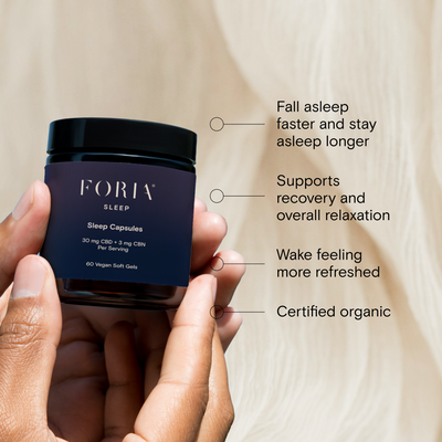Foria Sleep Capsules CBD container held by a hand with product features listed. Such as fall asleep, faster, and stay asleep longer and certified organic.